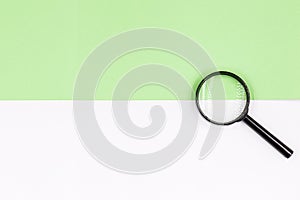 Magnifying glass on a white-green background. Top view