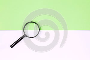 Magnifying glass on a white-green background. Top view