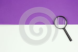 Magnifying glass on a white-lilac background. Top view