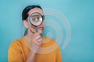 Magnifying glass. A woman\'s face through a magnifying glass. Big eyes. Research, choice concept