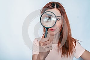 Magnifying glass. A woman's face through a magnifying glass. Long hair, big eyes. Research, choice concept