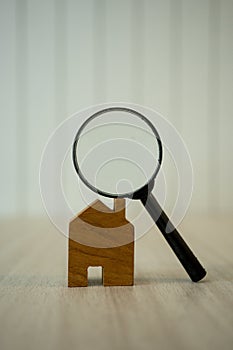 Magnifying glass on wood house for examining and analyzing quality, inspection and check home