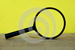 Magnifying glass on wooden desk with space customizable for text or ideas. Copy space