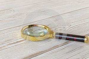 A magnifying glass on a wooden table. The concept of information search. Selective focus