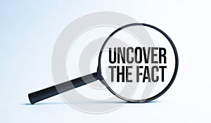 Magnifying glass with the word UNCOVER THE FACT. Business concept