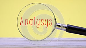 Magnifying glass on yellow background with text ANALYSYS on paper, concept of business, banking photo
