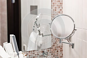 Magnifying mirror. Clean white towel and bathrobe on a hanger prepared to use. Bathroom Inside rooms of a apartment or