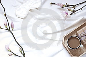 Magnolia flower flat lay morning in bed concept composition.