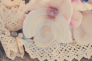 Magnolia flowers with pearls on wooden table photo