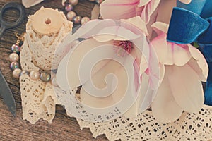 Magnolia flowers with pearls on wooden table photo