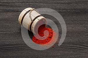 Magyar Hungarian brilliant red sweet paprika powder. Traditional seasoning for cooking national food. Wooden keg, black wooden