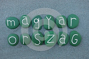 MagyarorszÃ¡g, Hungary, country name with green colored stones over green sand