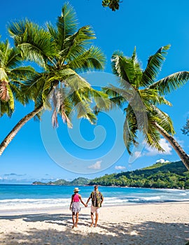 Mahe Seychelles, tropical beach with palm trees and, couple man and woman on vacation Seychelles
