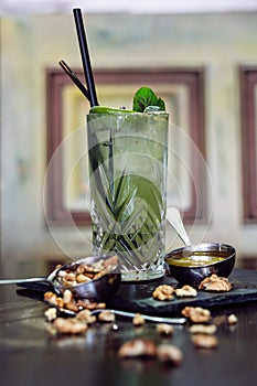 Mahito cocktail with with honey and walnuts on wooden table