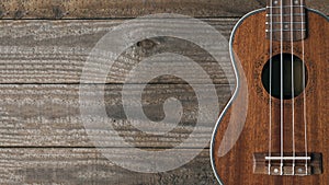 Mahogany ukulele resting on wooden planks, copy space 16:9 ratio