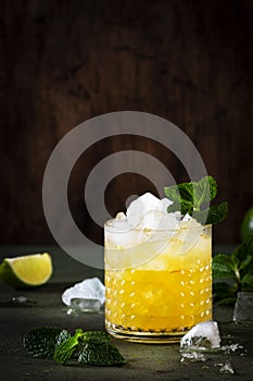 Mai Tai cocktail, refreshing drink with white rum, liqueur, sugar syrup, lime juice, mint and crushed ice. Dark background, bar
