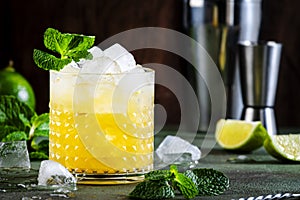 Mai Tai cocktail, refreshing drink with white rum, liqueur, sugar syrup, lime juice, mint and crushed ice. Dark background, bar