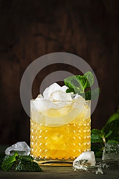 Mai Tai trendy alcoholic cocktail with rum, liqueur, syrup, lime juice, mint and crushed ice. Dark background, copy space