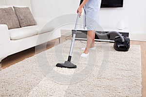 Maid cleaning carpet with vacuum cleaner