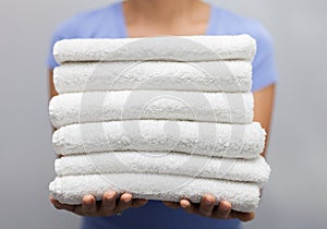 Maid holding a stack of fresh towels