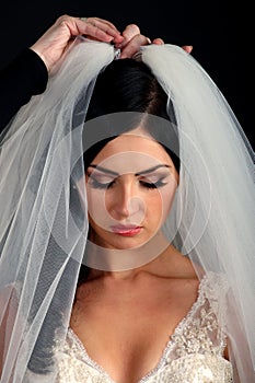 A maid of honor helping the bride with her dress