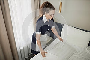 Maid Making Bed And Cleaning Hotel Room