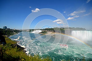 Maid of the Mist making it`s way to Horseshoe falls under a rainbow. Niagra Falls