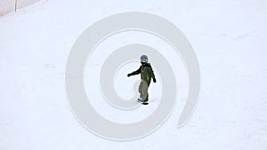 Maidan, Ukraine - February 20, 2021: little boy learning how to snowboard