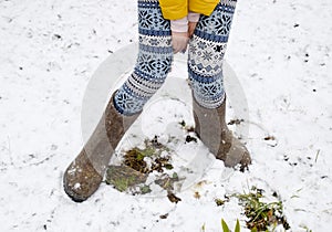 Maiden legs in warm pants and felt boots. The girl in the snow in the winter
