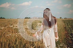 Maiden walking in a summer wheat field