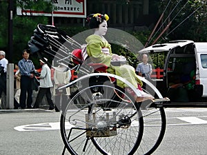 Maiko girl riding in a rickshaw, Kyoto Japan.