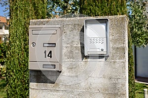 Mail box and intercom on grey concrete wall outdoors