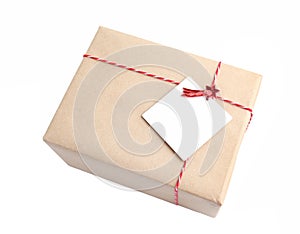 Mail parcel wrapped with craft brown paper with red twine isolated.