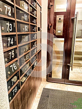 Mailboxes in the hallway or entrance. Hallway featuring numbered mailboxes next to glass doors. Residential Building