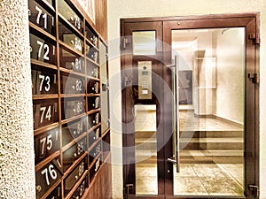 Mailboxes in the hallway or entrance. Hallway featuring numbered mailboxes next to glass doors. Residential Building