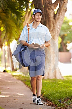 Mailman Walking Along Street Delivering Letters