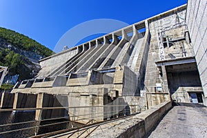 The main building with turbines of the Zeya hydroelectric station on the background of a concrete dam.