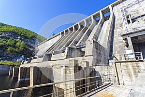 The main building with turbines of the Zeya hydroelectric station on the background of a concrete dam.