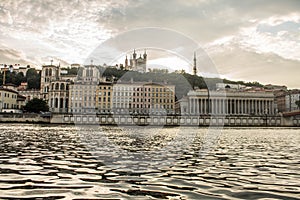 Main buildings of the city of Lyon at sunset with reflections of this in the water of the Rhone river that flows through the city