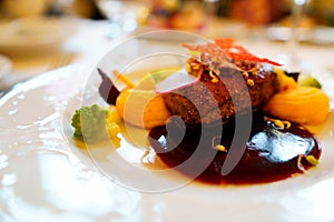 Main course in the restaurant. The food is nicely laid on a white plate with a delicate pattern. mouth-watering dish and