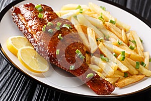 Main dish fried rockfish served with French fries close-up in a plate. horizontal