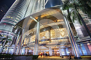 Main entrance into the Petronas Twin Towers, lit up at night by chandeliers and bright flood lights above