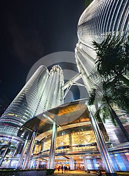 Main entrance into the Petronas Twin Towers, lit up at night by chandeliers and bright flood lights above