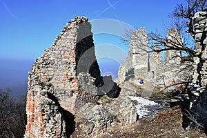 Hlavný vchod do zrúcaniny hradu Gymes, Slovensko, pozostatky vežového hradu na ľavej strane