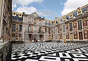 Main entrance of Versailles royal palace with ornate marble floor and decorative baroque fasade with columns