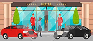 Main front entrance to luxury hotel with premium cars, doormen in red uniform and female visitor