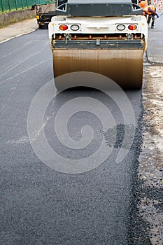 Main front wheel of Asphalt Roller compacts new asphalt in reconstruction of road