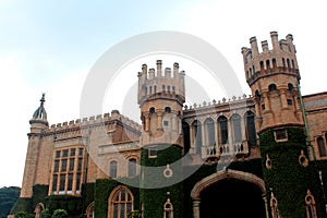 Main gate with battlement towers of bangalore palace with creeper plant.