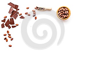 Main ingredient for chocolate. Cocoa beans near pieces of chocolate on white background top view copy space