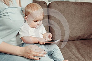 The main mistakes of the mother in a relationship with a small child. Mom with a small child in her arms using the phone to view